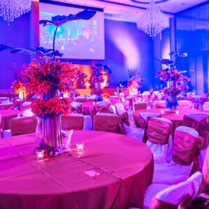 Luxury and colorful wedding reception dinner table setup with bouquet flower decoration in blue pink theme for sangeet night party of traditional indian wedding